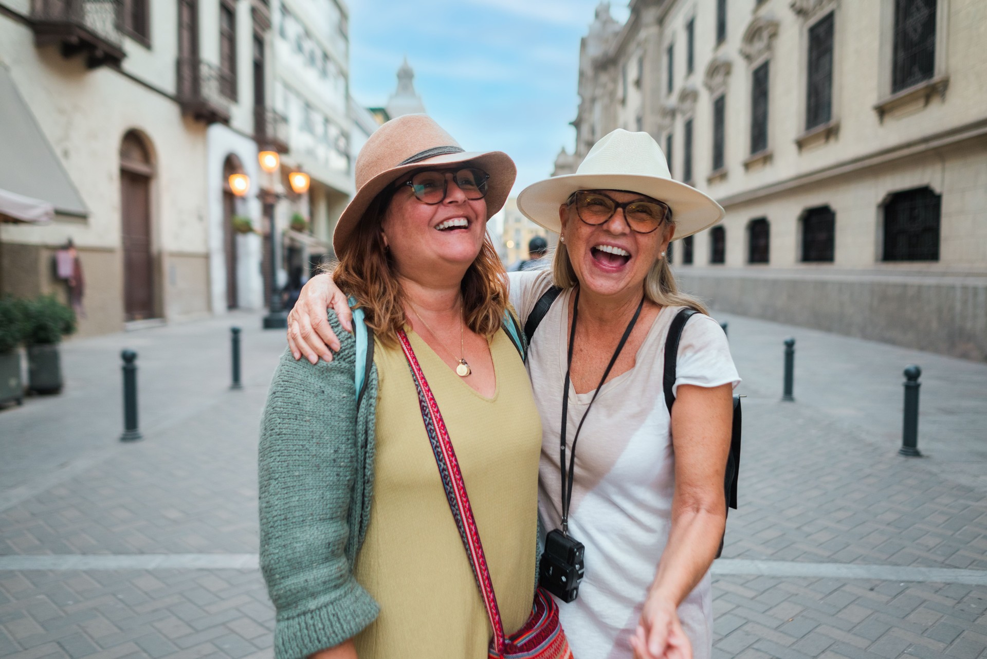 Two female tourists smile on a street in Lima Peru.